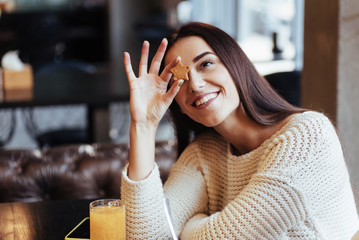 Friendly woman. Cute young brunette girl holds the cookie in the form of star with inscription that means best wishes