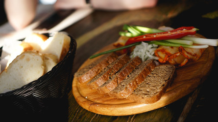 Slices of smoked brisket, fat bacon, dried chili pepper, pieces of bread on dark wooden table. Top view