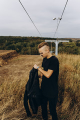 Young sexy man dress black leather jacket and sunglasses standing outdoor
