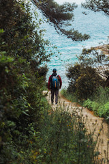 Obraz premium man walking by trial to sea beach overcast weather