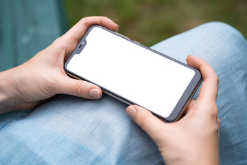 close-up view of young woman using her mobile phone with blank screen