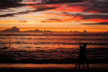 Obraz premium Background sky sunset,Silhouette Jogging on the beach,Bright in Phuket Thailand.