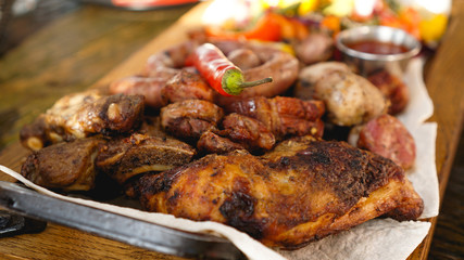 Mixed grilled meat platter. Assorted delicious grilled meat with vegetable. Mixed grilled meat with pepper sauce and vegetables.