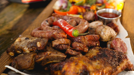 Mixed grilled meat platter. Assorted delicious grilled meat with vegetable. Mixed grilled meat with pepper sauce and vegetables.