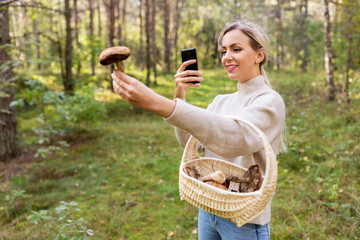 technology, people and leisure people concept - young woman with smartphone using app to identify...