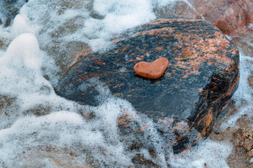 Heart of stone in the sea. Heart-shaped stone.