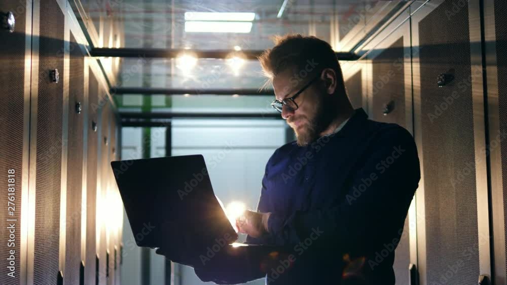 Aufkleber server technician working in modern data center. a person works with a laptop, standing in a data ce