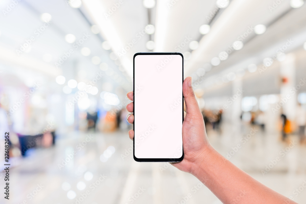 Aufkleber mockup image of hand holding mobile phone with blank white screen with blur office corridor hall way
