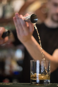 Bartender pouring whisky in a glass