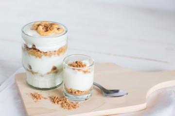 Healthy meal made of granola in glass, Yogurt and cornflakes Decorate food with Cashew Nut setting on white wooden table, healthy care concept, copy space