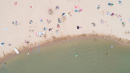 Aerial top view of people sunbathing swimming and relaxing in lake