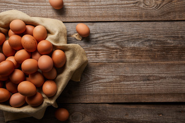 top view of chicken eggs at cloth on wooden table