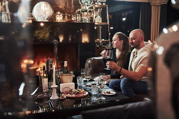 Tastes good. Girl with her boyfriend have nice evening at beautiful restaurant