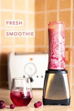 Fresh cherry smoothie in a blender on the kitchen board next to a glass of cherry drink with 'Fresh smoothie' title