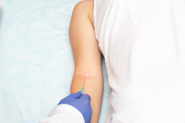 The doctor makes the intravenous laser blood purification of the patient's concept of rejuvenation...