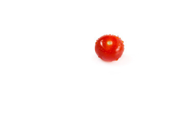 one small red cherry tomatoes with water droplets