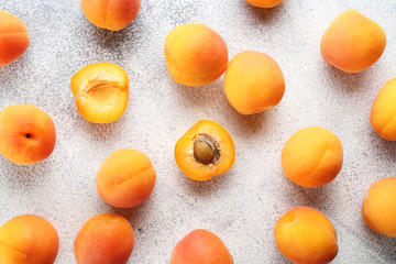Bunch of ripe organic apricots in pile on grunged concrete textured table. Local produce harvest heap. Clean eating concept. Background, top view, close up, copy space, flat lay.