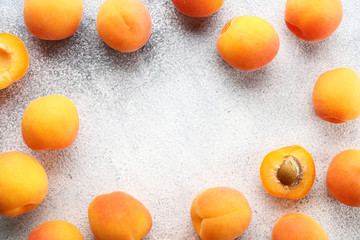 Bunch of ripe organic apricots in pile on grunged concrete textured table. Local produce harvest heap. Clean eating concept. Background, top view, close up, copy space, flat lay.