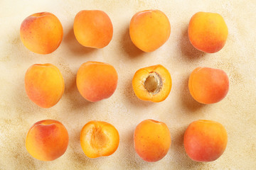 Bunch of ripe organic apricots in pile on grunged concrete textured table. Local produce harvest heap. Clean eating concept. Background, top view, close up, copy space, flat lay.