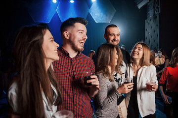 Making a jokes. Beautiful youth have party together with alcohol in the nightclub
