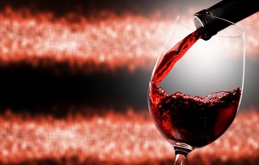 Red wine being poured in wineglass, closeup