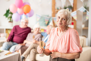 Gracious senior female with flute of champagne