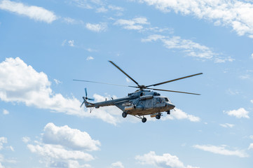 Naklejka na ściany i meble Flying military transport helicopter special for army soldier in fight war. Military soldier volant in transport helicopter above clean blue sky. Helicopter is military transport to army soldier