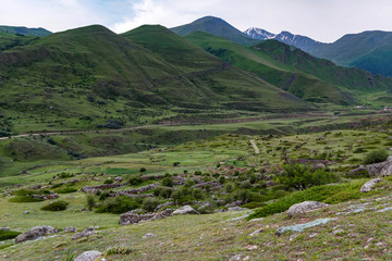 Fototapeta na wymiar Distant view of stone ruins and road in beautiful mountains in North Caucasus