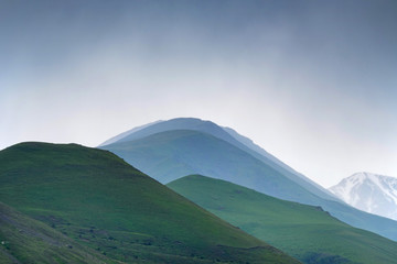 Fototapeta premium Scenic view of foggy mountains. Silhouettes in the evening