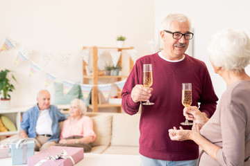 Senior spouses toasting with flutes of champagne
