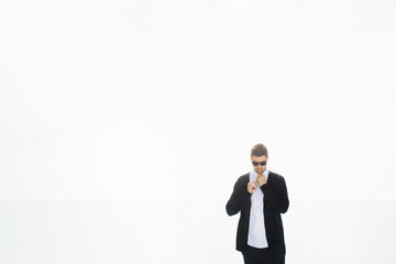 Calm man fixing his shirt on white background