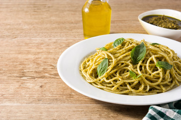 Spaghetti pasta with pesto sauce on wooden table. Copyspace