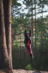 Teen boy at bungee in autumn forest in beauty sunny day
