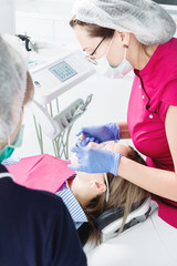 Close-up a young girl in a dentist's chair undergoes a routine diagnosis after removing braces with cleaning and sizing. Stamatology in life and in the clinic