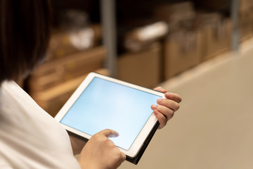 worker hand holding pad for check order pick time in smart factory warehouse