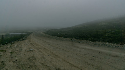 Empty road through foggy tundra