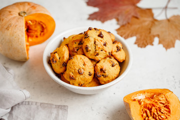 Pumpkin cookies with chocolate chips made from cake mix in a white ceramic bowl.