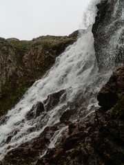 Stormy waters of the northern waterfall in a rocky gorge on the shores of the cold sea