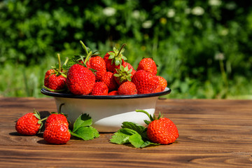 Fresh ripe strawberry on a wooden table outdoor