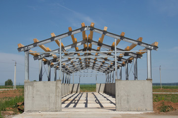 Background from the village hangar on construction site. Reinforced concrete base and metal frame of the building.