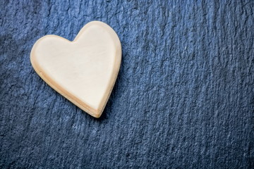 weißes herz auf einem schwarzen steinhintergrund