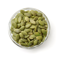 Top view of pumpkin seeds in glass bowl - obrazy, fototapety, plakaty