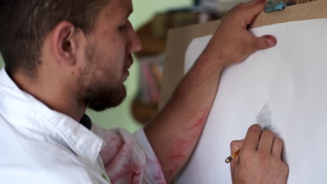 male artist and sketching a painting in the studio