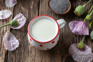 A cup of vegan milk with poppy seeds and plant