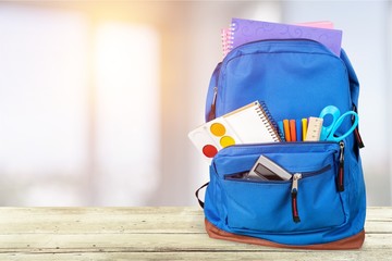 School Backpack with stationery on background