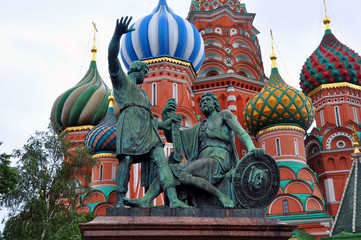 Fototapeta na wymiar Monument to Minin and Pozharsky on Red square in Moscow against green trees and walls of Saint Basil Cathedral