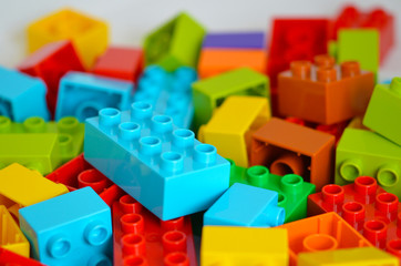 Colored toy bricks. Randomly laid out plastic building blocks, background. Children game.