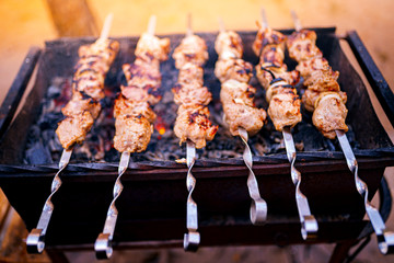 Grilled kebab cooking on metal skewer. Roasted meat cooked at barbecue. BBQ fresh beef meat chop slices. Traditional eastern dish, shish kebab. Grill on charcoal and flame, picnic, street food