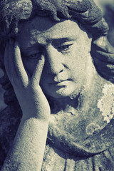 Statue of woman on tomb as a symbol of depression and sorrow (faith, religion, Christianity, death concept)