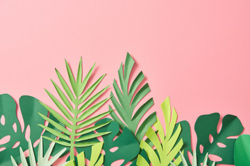 Fototapeta na wymiar top view of green palm leaves on pink background with copy space